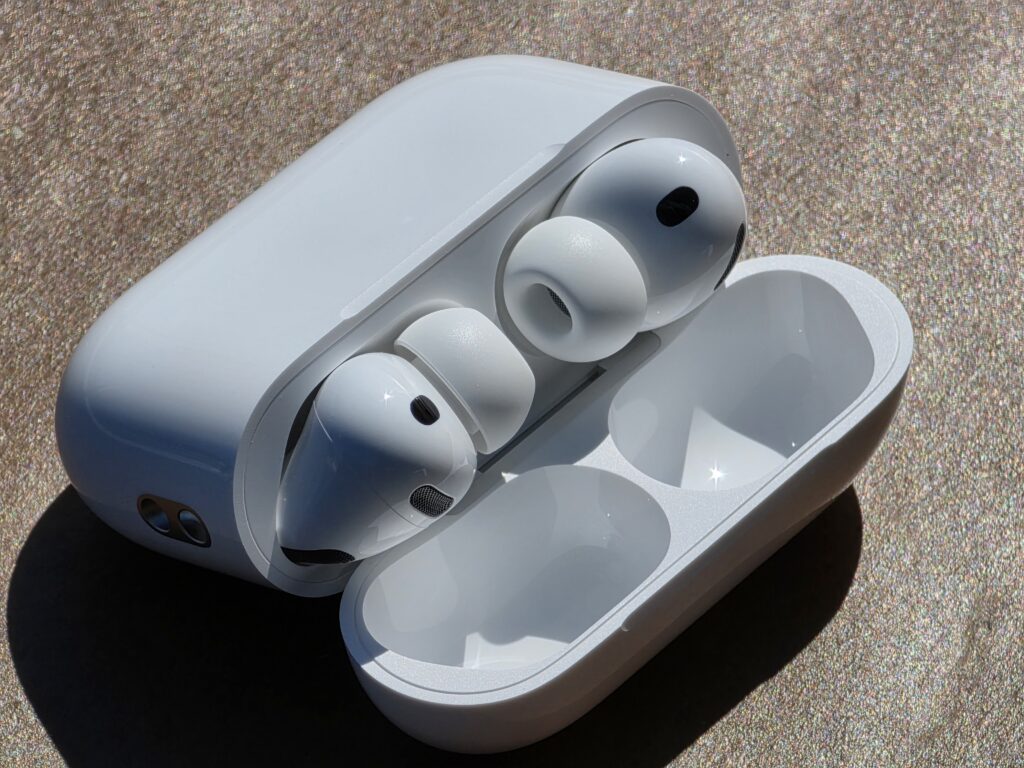 Closeup of Apple AirPods in their case, over a mottled brown background.