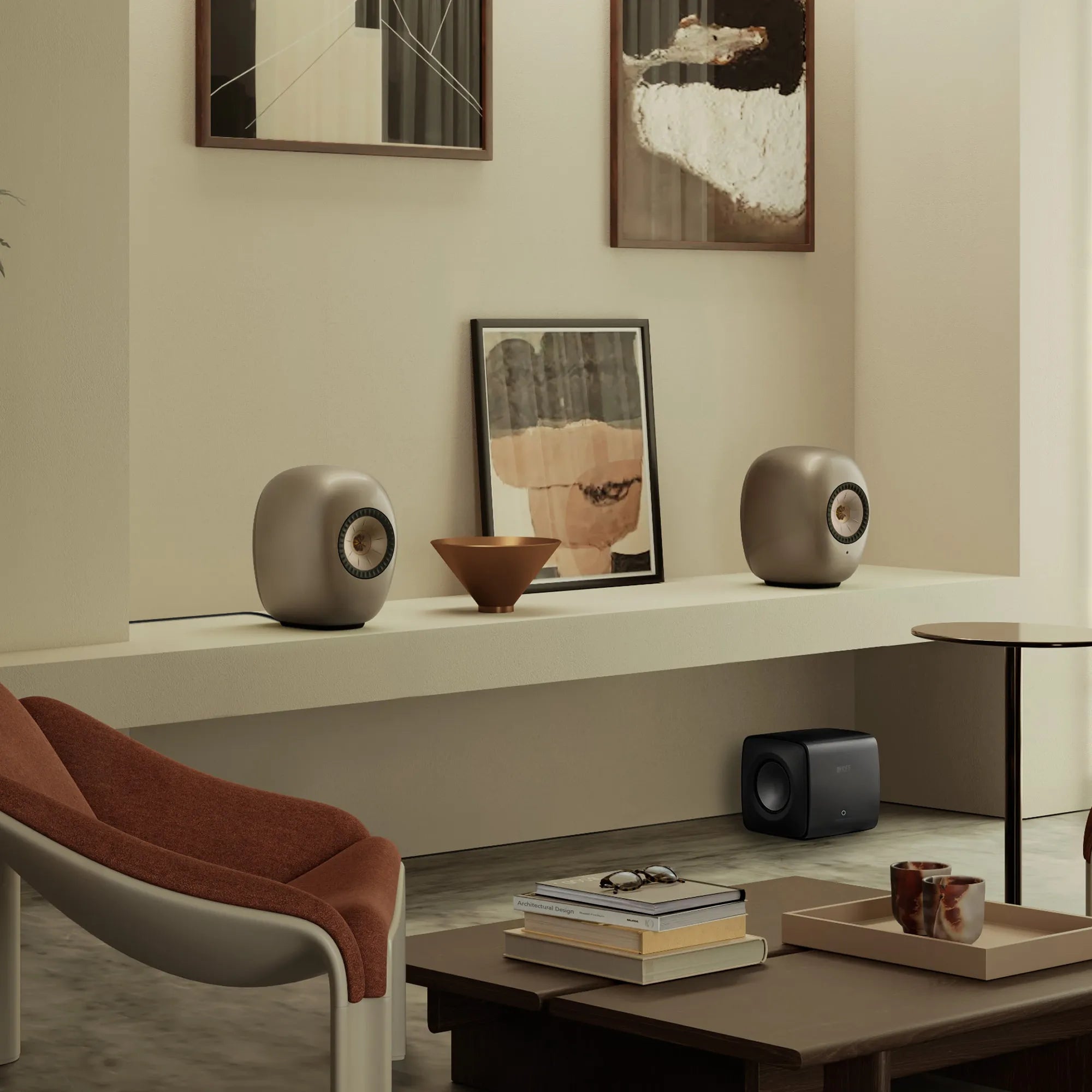 Pair of Dusk Titanium KEF LS LUXE wireless speakers on a shelf with a compact black KEF subwoofer in a modern living room.