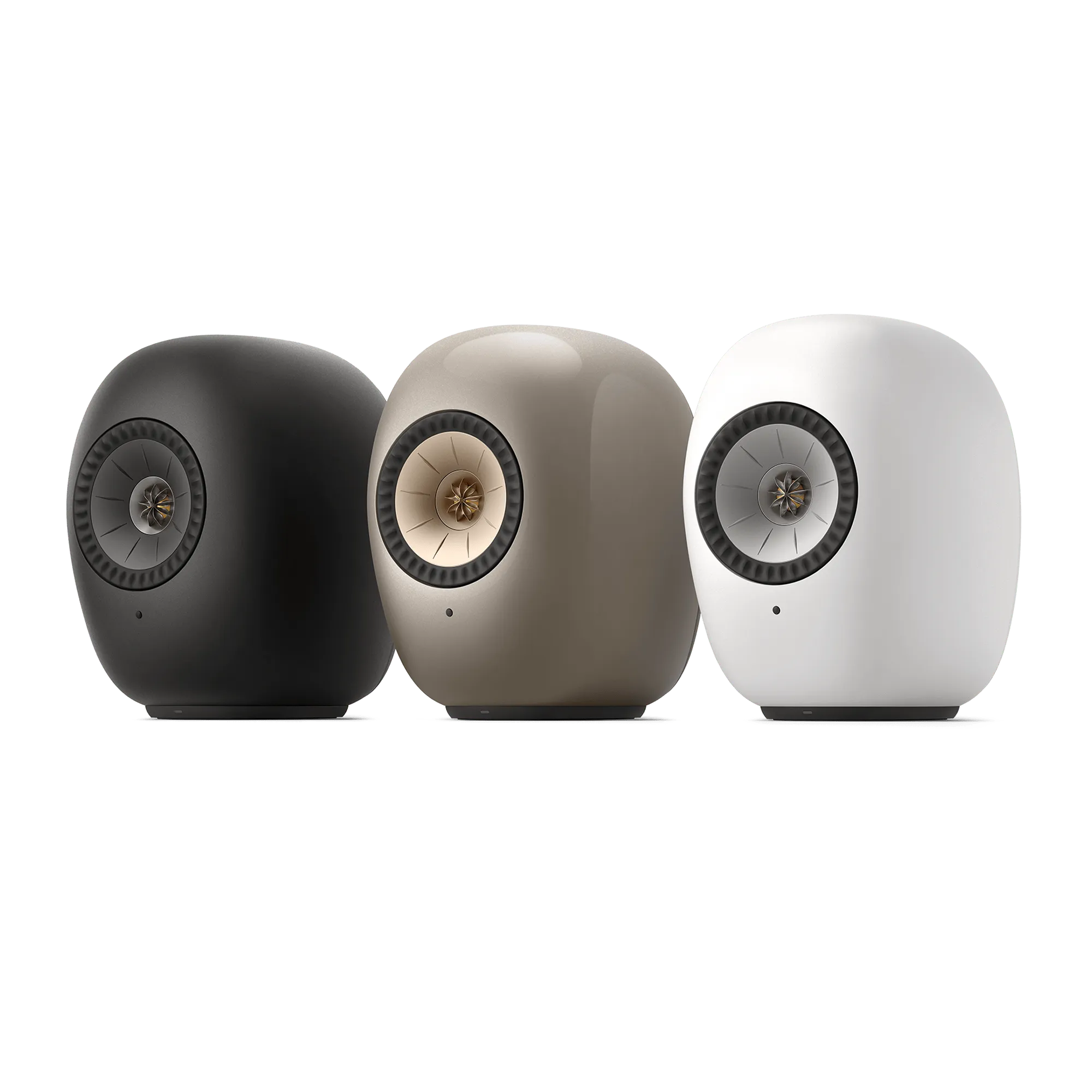 Three KEF LS LUXE wireless speakers shown in Eclipse Black, Dusk Titanium, and Mineral White.