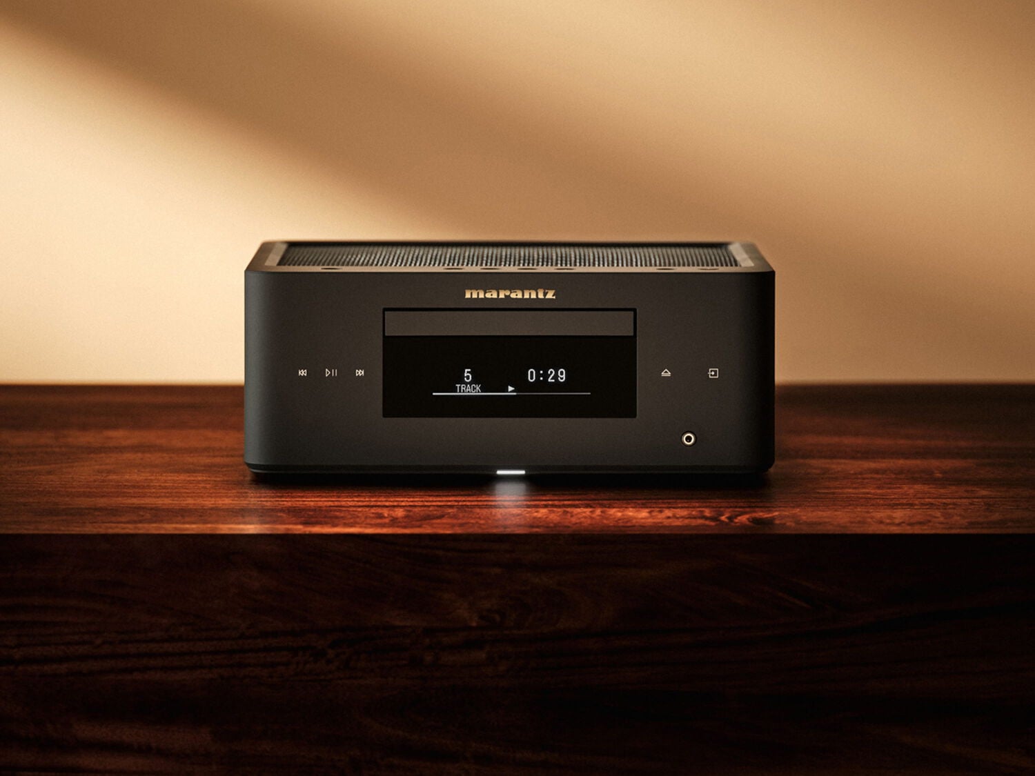 Black Marantz MCR 60n on a wooden shelf, showing its CD tray, display, and headphone socket