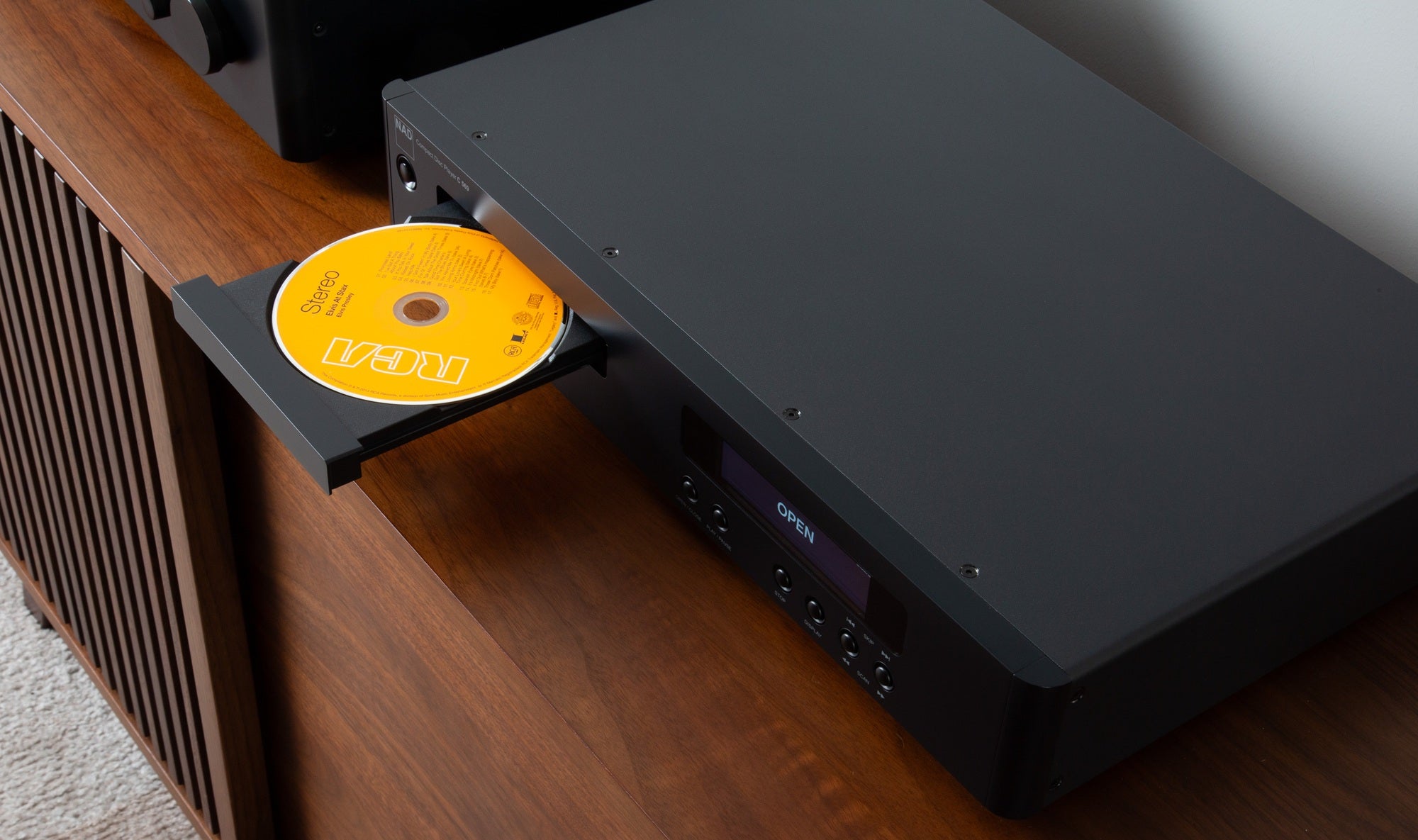 Overhead close-up view of a compact disc resting in the open tray mechanism of the NAD C 569 CD player