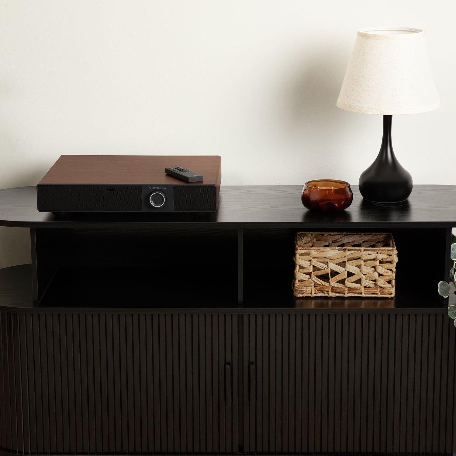 Walnut Victrola Soundstage powered speaker base positioned directly beneath a matching turntable on a wooden credenza